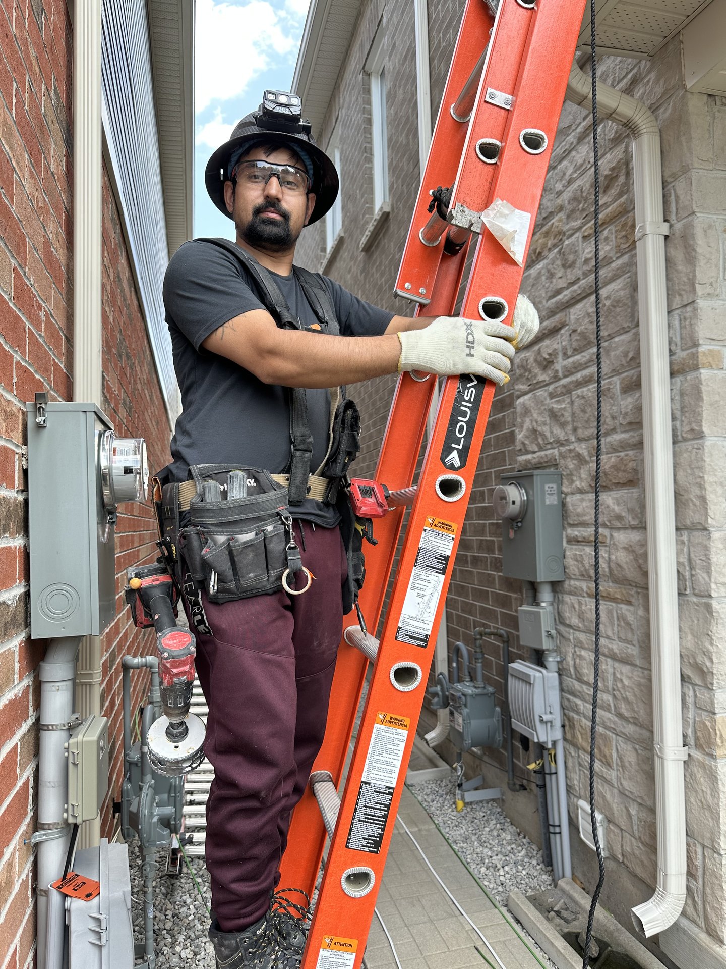 AMM Electric electrician on ladder installing exterior electrical